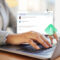 Person typing on a laptop with a digital alert icon on the screen, representing Phishing 2.0 and advanced AI-powered email security threats.