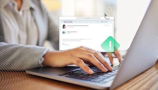 Person typing on a laptop with a digital alert icon on the screen, representing Phishing 2.0 and advanced AI-powered email security threats.